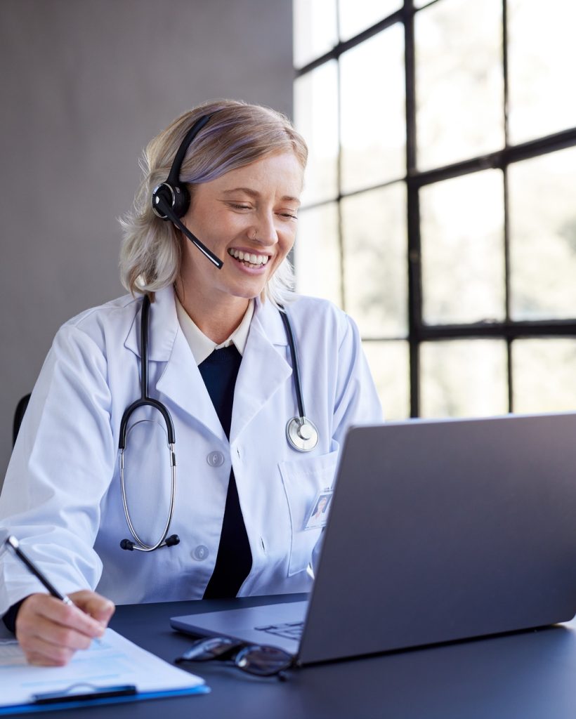 Happy female doctor conducting telemedicine consultation at office